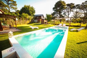 a swimming pool in the backyard of a house at Cabañas Chic Cumbre in Sierra de los Padres