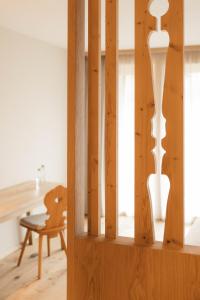 a wooden cabinet with a vase in a room at Boutique Hotel Pachers in Bressanone