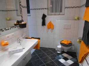 a bathroom with a sink and a toilet with orange towels at Apart Zangerle in Kappl