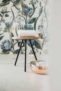 a stool with a bowl next to a wall at Boutique Hotel Pachers in Bressanone