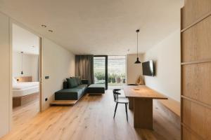 a small apartment with a desk and a bedroom at Boutique Hotel Pachers in Bressanone
