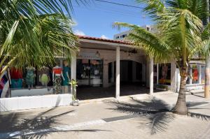 a building with palm trees in front of it at Flats & Suites Cheiro do Mar in Porto De Galinhas