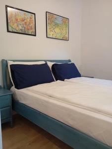 un letto in una camera con due immagini sul muro di villa Cretaccio Arco,bilocale in casa di campagna a 5 Min dal lago con deposito bici e attrezzatura ad Arco