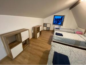 a room with two beds and a flat screen tv at Großzügiges Apartment am Rhein in Koblenz-Neuendorf in Koblenz