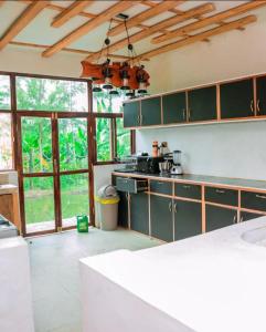 a kitchen with green cabinets and a large window at Ubuntu Kreative Village in Nairobi