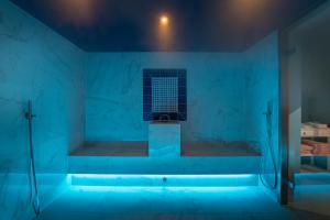 a blue bathroom with a tub with a window at Boutique Hotel Pachers in Bressanone