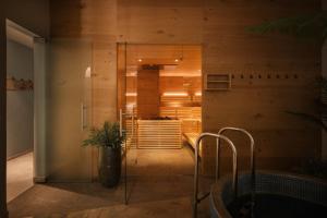 a bathroom with wooden walls and a glass wall at Boutique Hotel Pachers in Bressanone