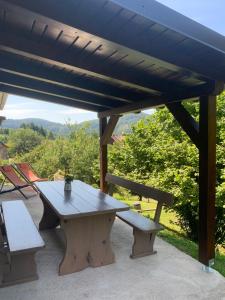 a picnic table and benches on a patio at NOOK studio apartman Lokve in Lokve