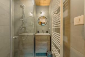 a bathroom with a shower and a sink and a mirror at Etoile des Vents 1 in Morzine