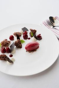 a white plate with dessert on a table at Boutique Hotel Pachers in Bressanone