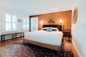 a bedroom with a large white bed with orange walls at Ellery Hotel Provincetown in Provincetown +18 photos