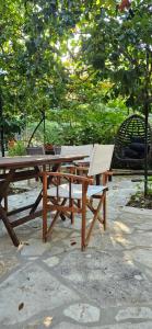 a wooden picnic table with chairs and a bench at Klejdi's house in Qeparo