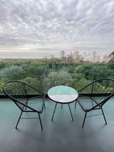two chairs and a glass table on a balcony at Mansion Botánico Premium Buenos Aires in Buenos Aires