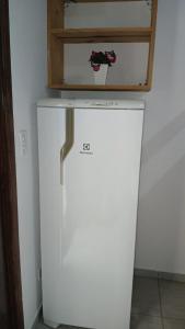 een witte koelkast met een kastje erbovenop bij Pousada Beira Mar in Mongaguá