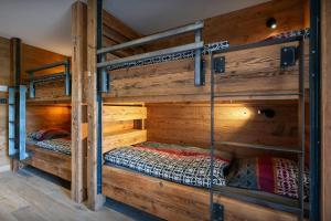 two bunk beds in a room with wooden walls at Chalet K1027 - OVO Network in Cordon