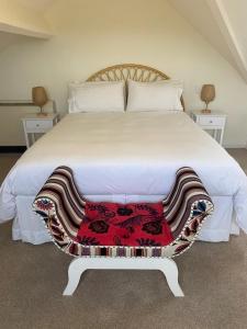 a bedroom with a large white bed with two tables at Newton House Apartment, Newton Burgoland in Heather