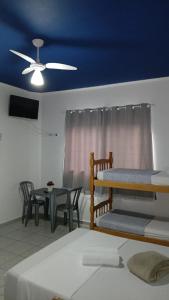 een kamer met 2 stapelbedden en een tafel met stoelen bij Pousada Beira Mar in Mongaguá