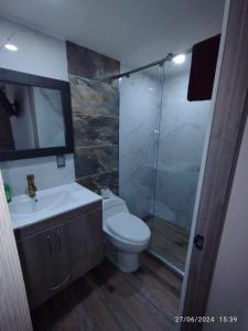 a bathroom with a toilet and a glass shower at Apartamento en Cartago Valle - Hospedaje in Cartago