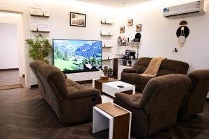 阿尔阿尔Zeo home suite的客厅配有2把椅子和平面电视