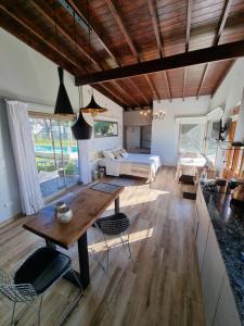 a living room with a table and a bed at Cabañas Chic Cumbre in Sierra de los Padres