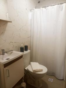 a bathroom with a toilet and a white shower curtain at Casa de Dani, acogedora casa decorada con estilo moderno y funcional 400 mts del mar in Playa Hermosa +35 photos