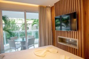 a bedroom with a table and a television on a wall at In Mare Bali Resort Beira Mar em Cotovelo by Qavi in Granja Beira Mar +20 photos