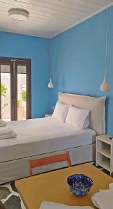 een blauwe slaapkamer met een bed en een tafel bij Dendrinos studio in Galissas