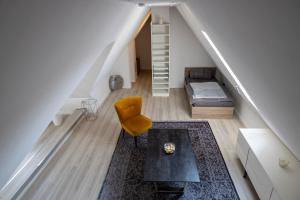 a living room with a yellow chair and a staircase at Ferienwohnung in Karlburg in Karlstadt