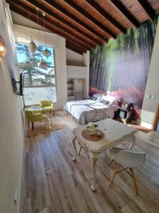 a bedroom with a bed and a table at Cabañas Chic Cumbre in Sierra de los Padres