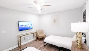 a bedroom with a bed and a tv and a chair at Xlnc Exotic Home Gillespie Drive in Spring Valley