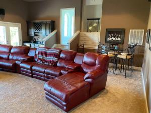a living room with a leather couch and a table at The Big House on Pleasant Valley Farm in Columbia