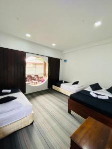 a hotel room with two beds and a table at The Hobbit Cottage-Ella in Ella