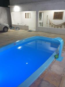 a large blue pool in a garage with a car at Casa Praia BRISAMAR in Maragogi