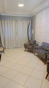 a living room with two couches and a large window at Apart 3qtrs á 1200m da praia de Itapuã in Vila Velha