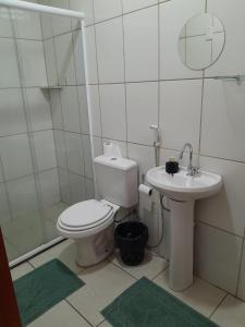 a white bathroom with a toilet and a sink at HOTEL POUSADA SÃO PEDRO MATÃO in Matão