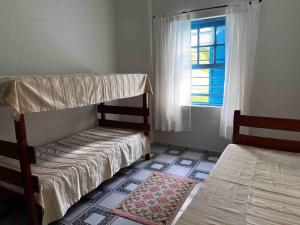 a bedroom with two bunk beds and a window at Casa Acuri in Jacareí