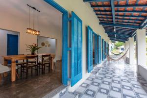 a dining room with blue shutters and a table at Casa Acuri in Jacareí