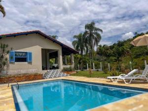 a house with a swimming pool in front of a house at Casa Acuri in Jacareí