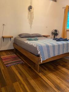 a bed in a bedroom with a wooden floor at Caribbean Retreats in Cocles