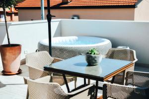 a table and chairs on a patio with a hot tub at Wine Apartment Brkic in Čitluk