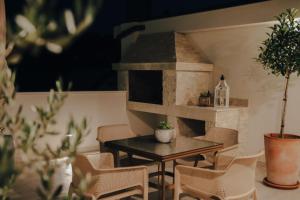 a table and chairs in a room with a pizza oven at Wine Apartment Brkic in Čitluk