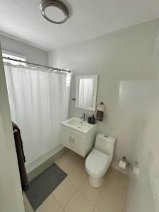 a white bathroom with a toilet and a sink at Gorgeous Remodeled Gem Santurce IV in San Juan