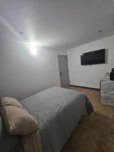 a bedroom with a bed and a flat screen tv on the wall at Santurce Studios Newly Renovated 6 in San Juan