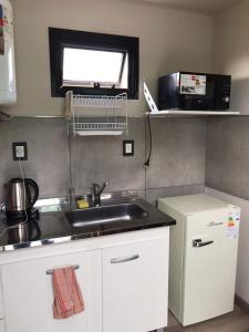 a kitchen with a sink and a microwave at Posada de los topos in Tandil +13 photos