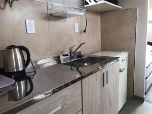 a kitchen with a sink and a refrigerator at Posada de los topos in Tandil