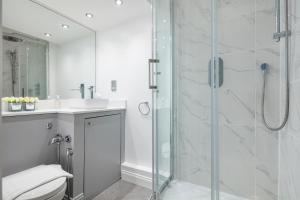 a bathroom with a shower and a toilet and a sink at Kensington 1bd apt seconds from Museums in London