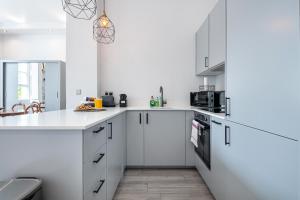 a white kitchen with white cabinets and appliances at Kensington 1bd apt seconds from Museums in London +11 photos