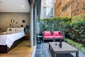 een slaapkamer met een bed, een bank en een tafel bij AR 218 Hotel by ULIV in Mexico-Stad