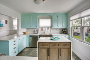una cucina con armadi blu e piano di lavoro di Waterfront Views Historic Marblehead Home a Marblehead