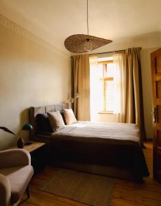 a bedroom with a bed and a couch and a window at K&L Old Town Kuldīga in Kuldīga